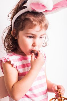 Girl eats a chocolate little eggs after Easter hunting