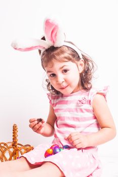 Girl eats a chocolate little eggs after Easter hunting