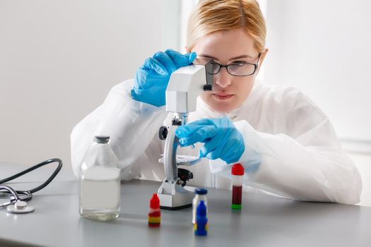 Woman working with a microscope in lab