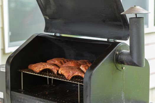 Beef Ribs Cooking on Barbecue Grill. Backyard BBQ party concept