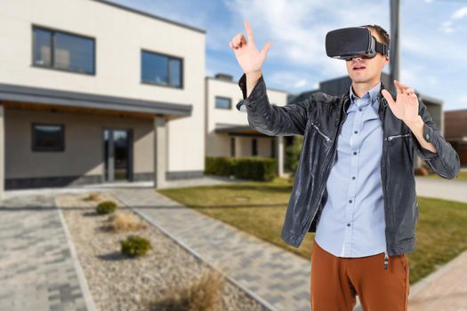 Cheerful man in virtual glasses in front of new house.