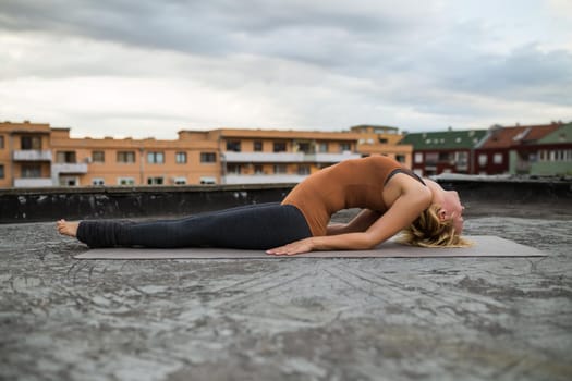 Woman practicing yoga on the roof,Matsyendrasana/Fish pose with straight legs