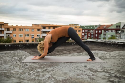 Woman  enjoys practicing yoga on the roof of a building,Parsvottanasana /Intense side stretch.