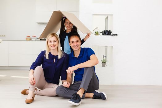 happy family sitting together and making the home sign