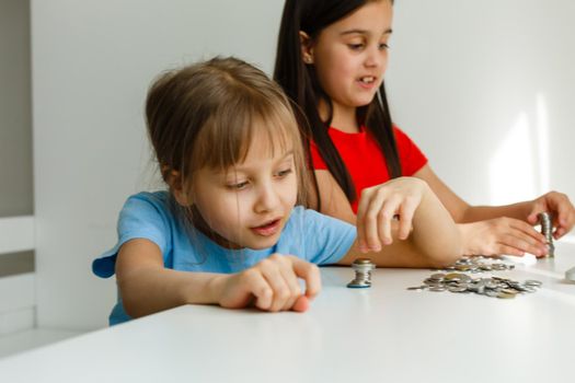 portrait of little girls sitting at table and calculating money