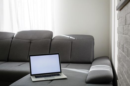 Modern interior. Comfortable workplace. The laptop is on the couch