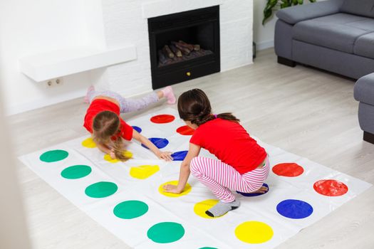 two little girls Having Fun Playing Game On Floor At Home. Siblings Friendship