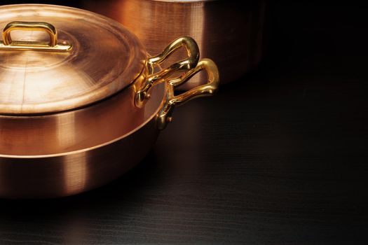 Shiny vintage copper cookware over dark background. High quality photo