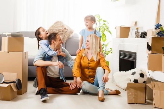 Happy family with cardboard boxes in new house at moving day.