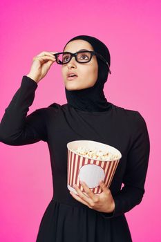 Muslim woman entertainment cinema popcorn fashion purple background. High quality photo