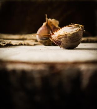 Garlic cloves and natural linen napkin on rustic wooden background