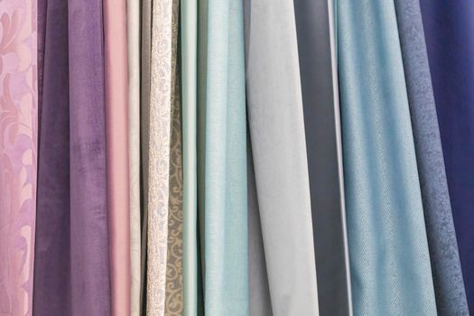 multicolored textures of fabrics on the shelves of stores close-up. High quality photo