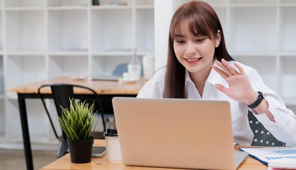 Asian young businesswoman sitting and happy working with laptop computer connect internet in desk office.