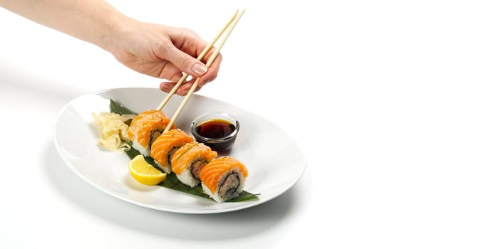 Sushi and soy sauce in a white bowl and white wooden chopsticks white table. Japanese food. Japanese seafood Sushi Set. Sushi bar Menu. isolated