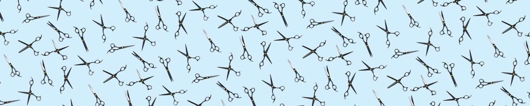 Background of black scissors. professional hairdresser black scissors isolated on blue. Black barber scissors, close up. pop art background, for prints or posters. not seamless pattern