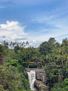 Waterfall flowing over rocky river in jungle, Bali, Indonesia - stock photo