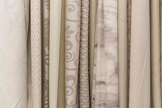 multicolored textures of fabrics on the shelves of stores close-up. High quality photo