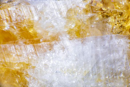 macro shooting of natural rock specimen. Raw crystal of Citrine yellow quartz gemstone from Brazil. Shimmering gold background. High quality photo