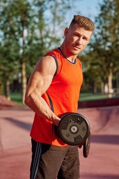 Muscled Man With Dumbbells Outdoor Workout. High quality photo