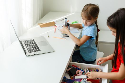 Pretty stylish schoolgirls studying during her online lesson at home, social distance during quarantine, self-isolation, online education concept