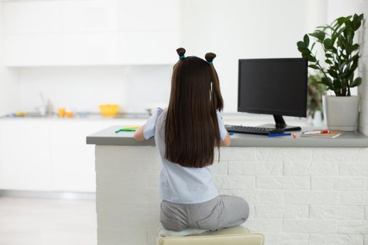 Pretty stylish schoolgirl studying homework math during her online lesson at home, social distance during quarantine, self-isolation, online education concept, home schooler