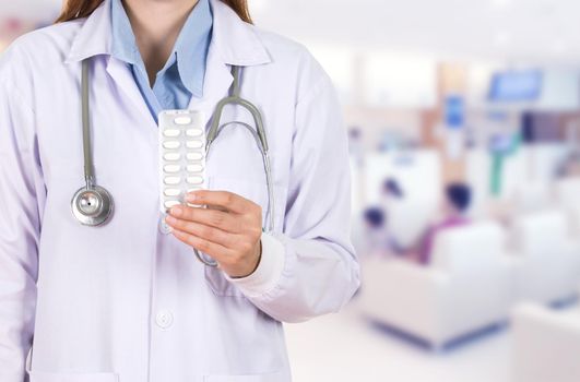 female doctor holding with pills in hospital background