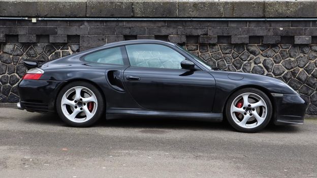 Dusseldorf, Germany - February 28, 2020: side view of a black Porsche 991 car parked on the street. Second generation car. German car manufacturer founded by renowned designer Ferdinand Porsche.