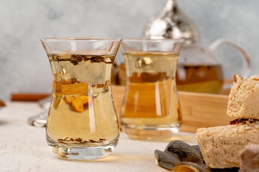 Turkish halva with tea in a glass cup close up on table