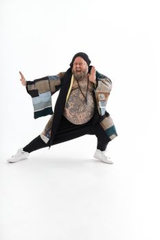 Fat stylish bearded tattoed caucasian man with big belly is posing and dancing wearing ethnic kimono