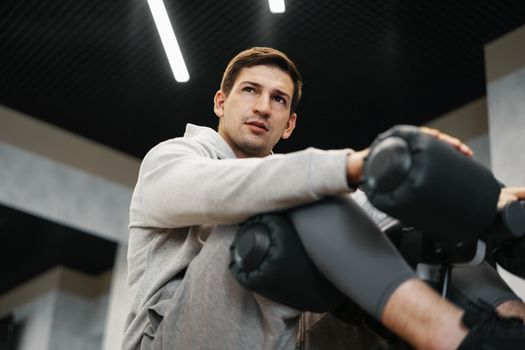 Young athlete doing abs exercises workout in modern gym, close up