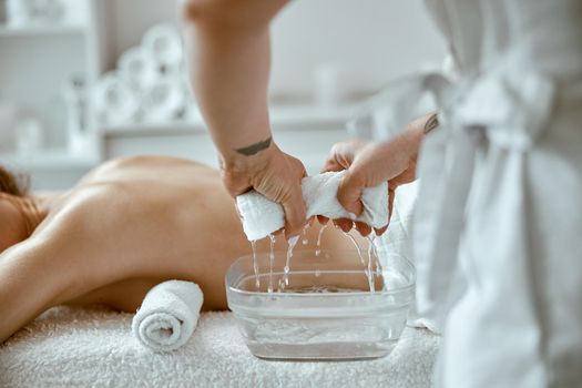 confident female specialist is doing relaxing body massage for beautyful slim caucasian lady at minimalistic spa salon