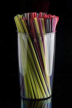 colourful bunch of straw were put in a glass cup