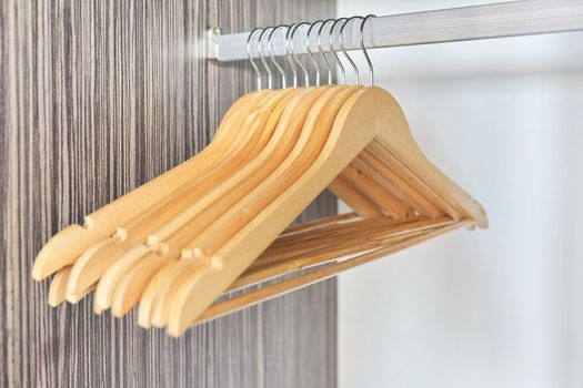 Wooden hangers in an empty open cabinet. Clothing, fashion, shopping, new home, wardrobe organization concept