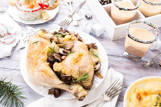 Delicious Christmas themed dinner table with roasted chicken, appetizers and desserts. Holiday concept.