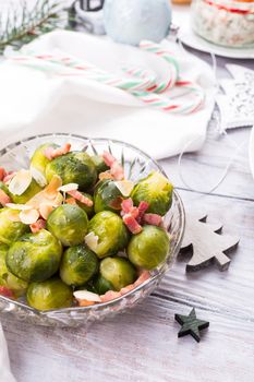 Brussels sprouts with fried bacon and almonds. Delicious Christmas themed dinner table. Holiday concept.