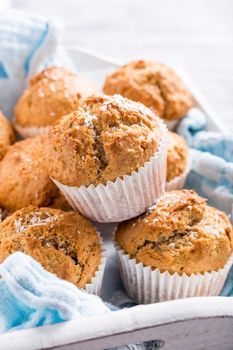 Delicious homemade coconut cinnamon muffins on old white tray. Healthy food concept.