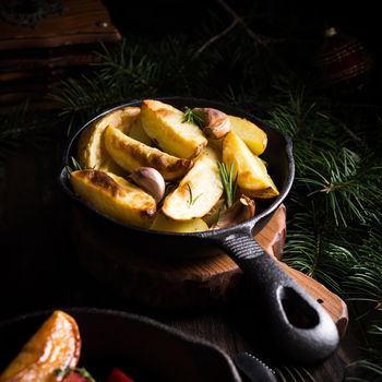 Delicious Christmas themed dinner table with baked potatoes and garlic. Holiday concept with copy space.