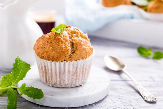 Delicious homemade coconut cinnamon muffin on marble coasters. Healthy food concept.