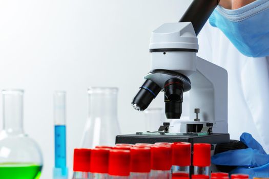 Close up photo of woman scientist working with microscope in laboratory