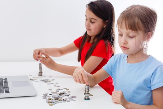 portrait of little girls sitting at table and calculating money