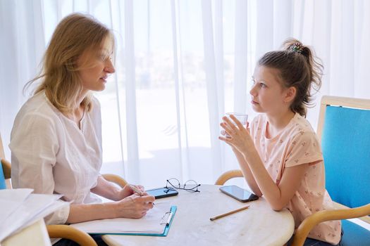 Child girl at session with social worker, school psychologist in an office. Child psychology, professional help, mental health of children, conversation between counselor and preteen girl