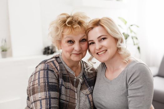 happy senior mother and adult daughter closeup portrait at home