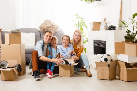 Happy family with cardboard boxes in new house at moving day.