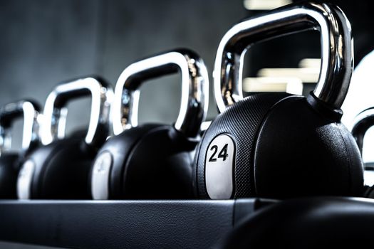 Close up photo of new dumbbells on a rack in a gym