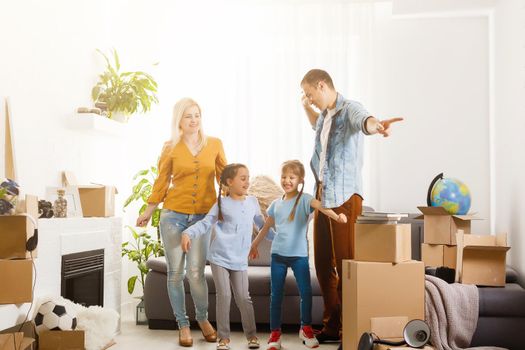 Family with cardboard boxes standing in row at home