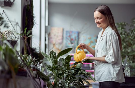Confident female florist is working with dryed flowers in cozy flower shop