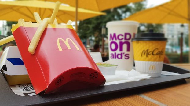 Hamburger, French fries, coffee and Coca Cola soft drink on the table in the McDonald's restaurant. Branches all over the world. Ukraine, Kiev - September 6, 2019