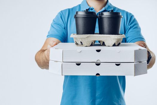 Unrecognizable man in blue polo shirt with food delivery orders against light grey background