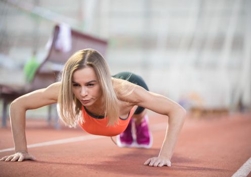 Young fit athletic woman doing push ups. Mid shot