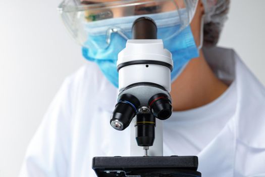 Close up photo of woman scientist working with microscope in laboratory